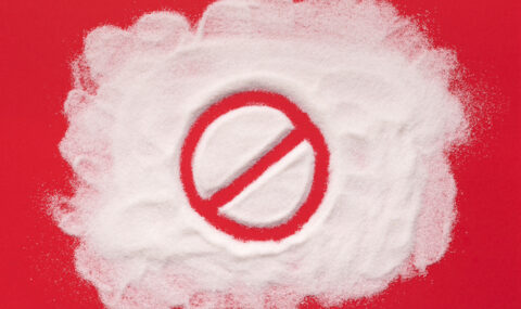 Stop prohibition sign on white sugar background